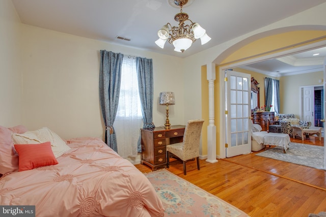 bedroom featuring a chandelier, hardwood / wood-style flooring, and ornamental molding