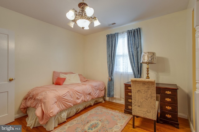 bedroom with a chandelier and wood-type flooring