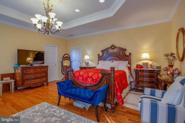 bedroom featuring a notable chandelier, light hardwood / wood-style floors, a raised ceiling, and ornamental molding