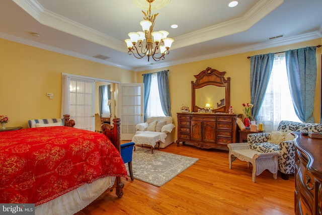 bedroom with a raised ceiling, wood-type flooring, and ornamental molding