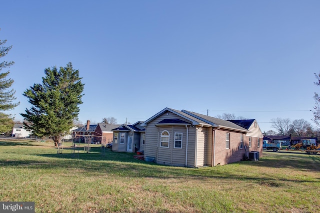 view of property exterior featuring central AC and a lawn