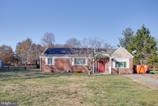 view of front facade featuring a front yard and solar panels