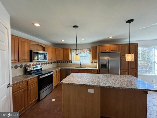 kitchen with appliances with stainless steel finishes, a center island, and a healthy amount of sunlight