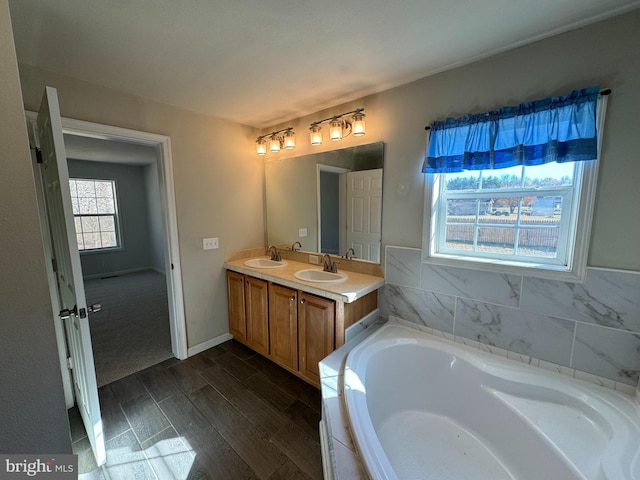 bathroom featuring hardwood / wood-style flooring, vanity, and a tub