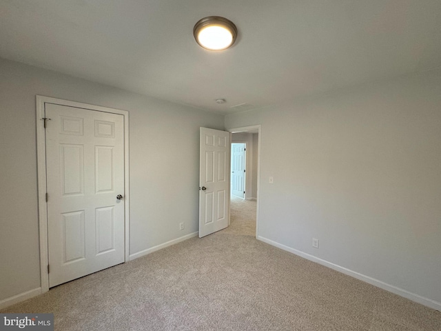 unfurnished bedroom featuring light carpet