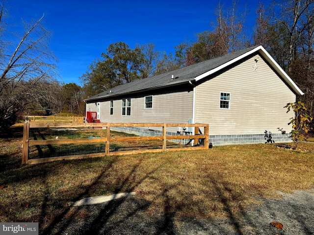 view of side of home with a yard