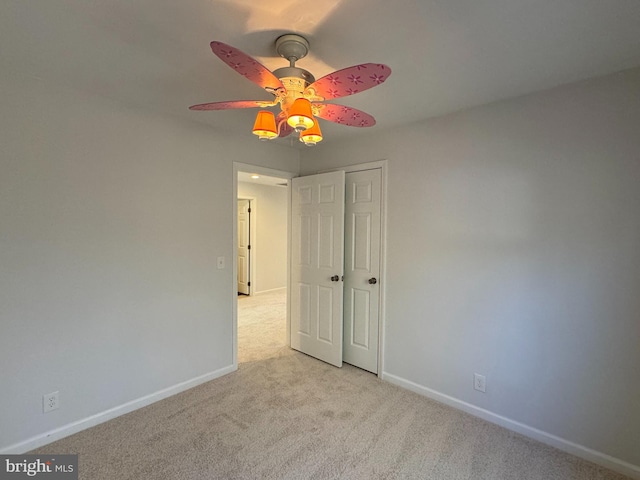 carpeted spare room featuring ceiling fan