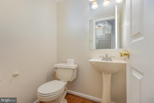 bathroom featuring wood finished floors, toilet, and baseboards