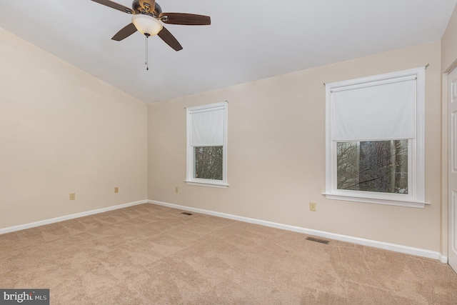 carpeted empty room with baseboards, visible vents, and a ceiling fan