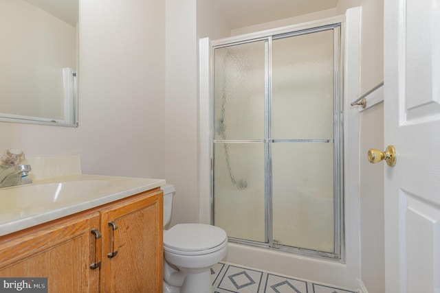 bathroom with a shower stall, toilet, and vanity