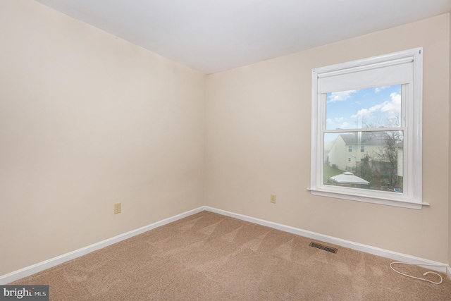 unfurnished room featuring carpet flooring, visible vents, and baseboards