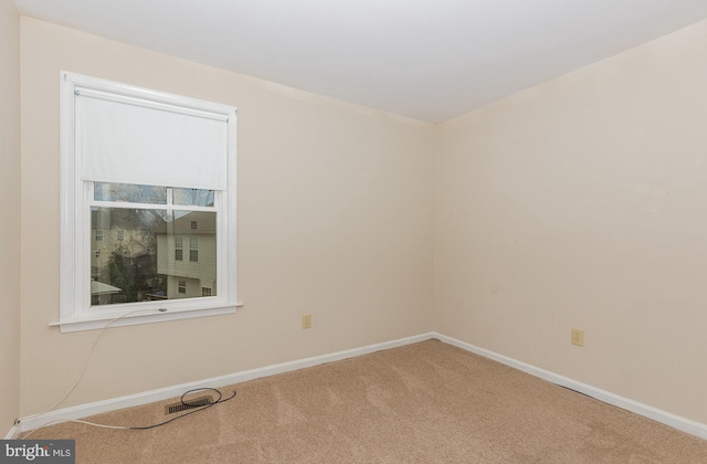 carpeted empty room featuring baseboards