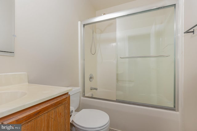 full bath featuring combined bath / shower with glass door, vanity, and toilet