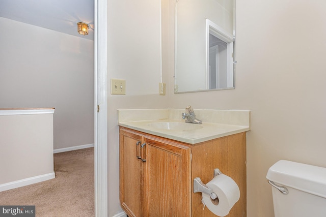 bathroom featuring baseboards, vanity, and toilet