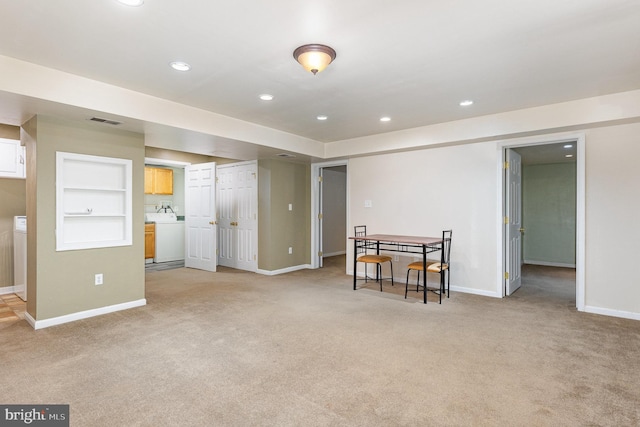 spare room with washer / dryer, recessed lighting, light carpet, and visible vents