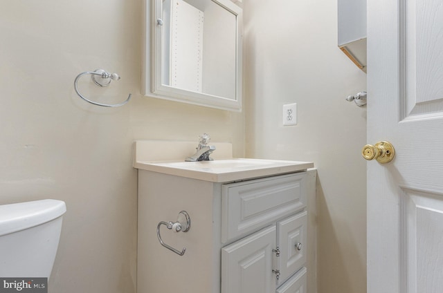 half bathroom with vanity and toilet