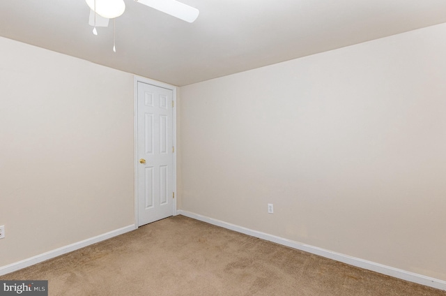 carpeted empty room with ceiling fan and baseboards