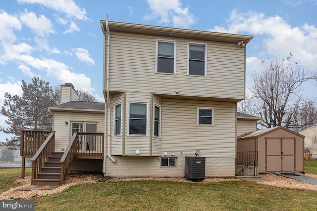 back of house with a storage shed, an outbuilding, a deck, a yard, and central air condition unit