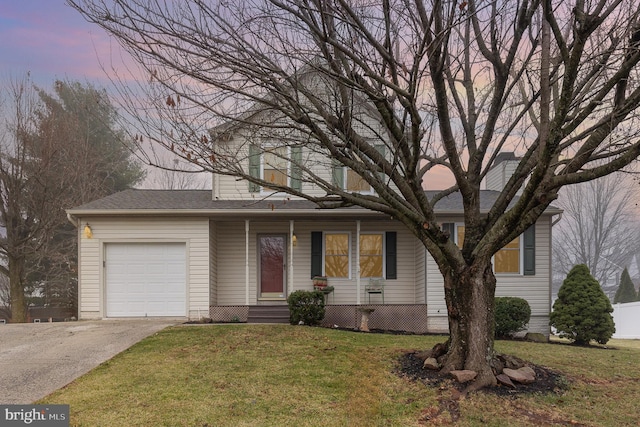 view of front of house with a garage, driveway, and a front lawn