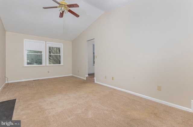 carpeted empty room featuring lofted ceiling, ceiling fan, and baseboards