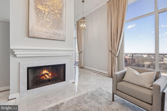 sitting room with a notable chandelier, a fireplace, and crown molding