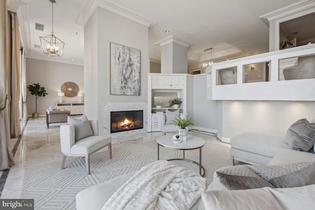 living room with a premium fireplace, crown molding, and a chandelier