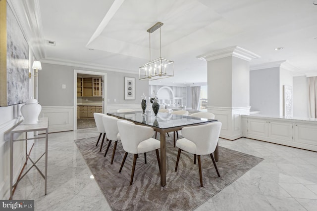 dining area featuring ornate columns and crown molding