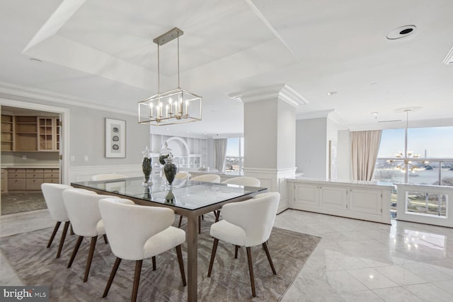 dining space with ornamental molding, a healthy amount of sunlight, and a notable chandelier