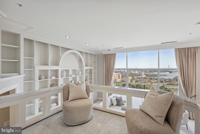 living area featuring built in shelves and ornamental molding