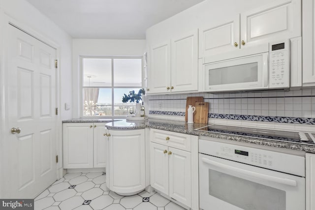 kitchen with decorative backsplash, white appliances, and white cabinetry