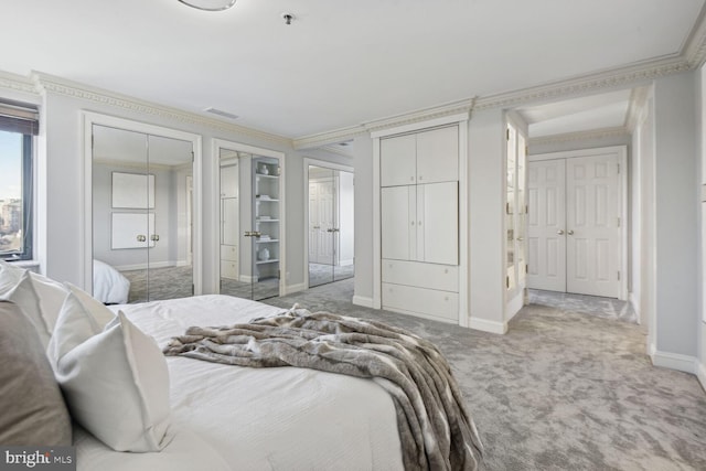 carpeted bedroom with multiple closets and ornamental molding