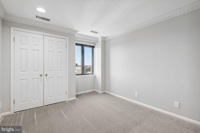 unfurnished bedroom with carpet flooring, a closet, and ornamental molding