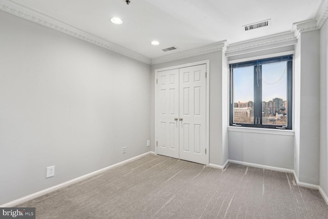 unfurnished bedroom with ornamental molding, light carpet, and a closet