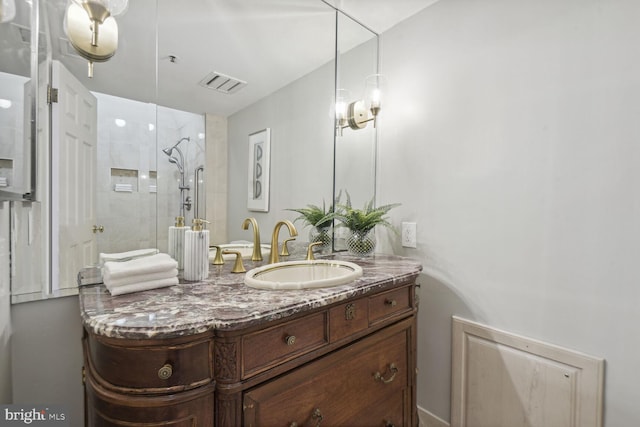 bathroom with vanity and a tile shower