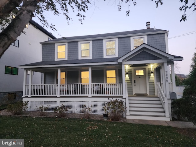 view of front of home with a lawn and a porch