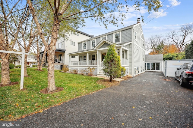 front of property with covered porch and a front yard