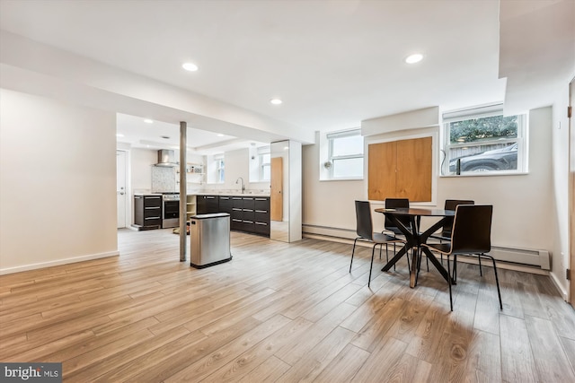 dining area with light hardwood / wood-style floors, a healthy amount of sunlight, and sink