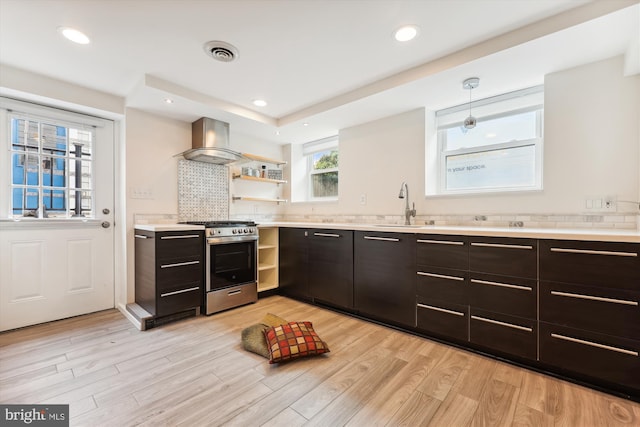 kitchen featuring pendant lighting, backsplash, wall chimney range hood, stainless steel range, and dark brown cabinetry