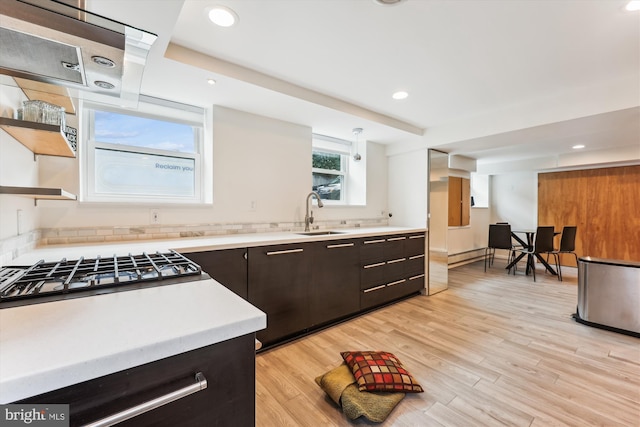 kitchen with dark brown cabinetry, sink, light hardwood / wood-style flooring, a baseboard heating unit, and stainless steel gas stovetop