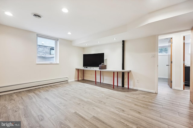 unfurnished living room with light hardwood / wood-style floors and baseboard heating