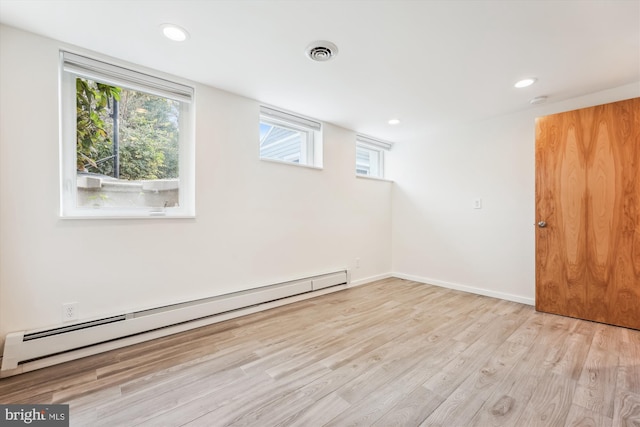 spare room with a wealth of natural light, light hardwood / wood-style flooring, and a baseboard heating unit