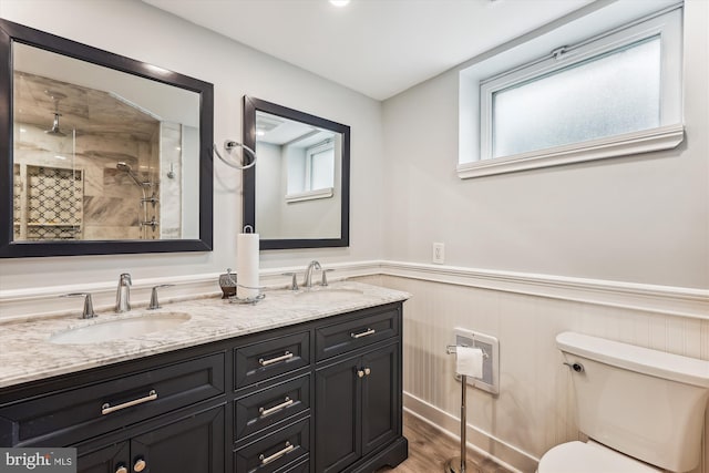 bathroom featuring hardwood / wood-style flooring, vanity, a healthy amount of sunlight, and walk in shower