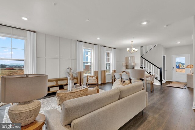 living room featuring dark hardwood / wood-style flooring, an inviting chandelier, and plenty of natural light