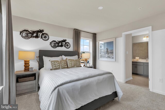 bedroom with light colored carpet, ensuite bath, and sink