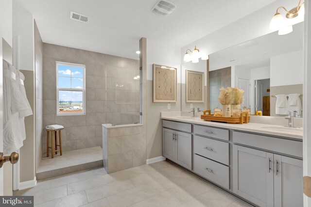 bathroom featuring tile patterned floors, vanity, and a tile shower