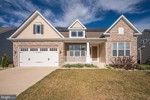 craftsman-style house featuring solar panels, a porch, a front lawn, and a garage