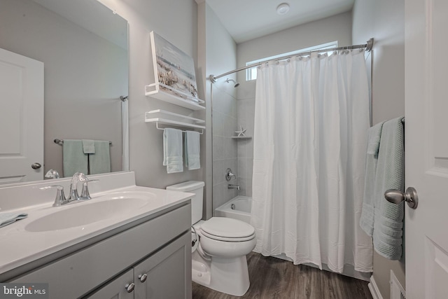 full bathroom with hardwood / wood-style floors, vanity, shower / tub combo, and toilet