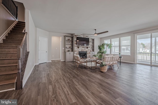 unfurnished living room with hardwood / wood-style flooring, ceiling fan, and a stone fireplace