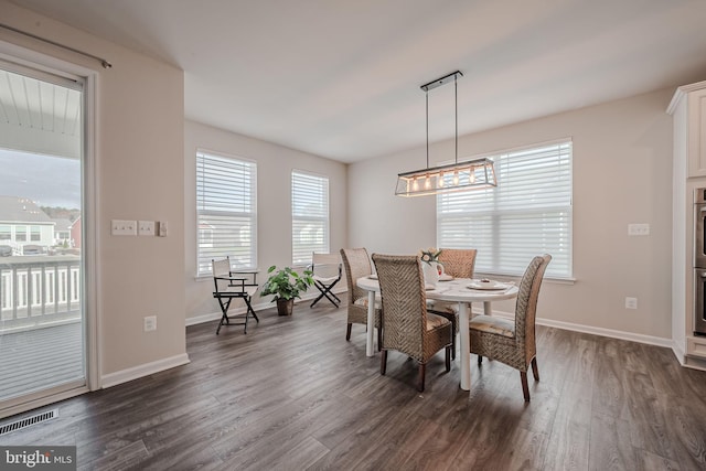 dining space with dark hardwood / wood-style flooring