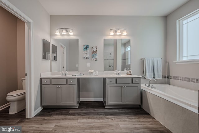 full bathroom with vanity, toilet, wood-type flooring, and plus walk in shower